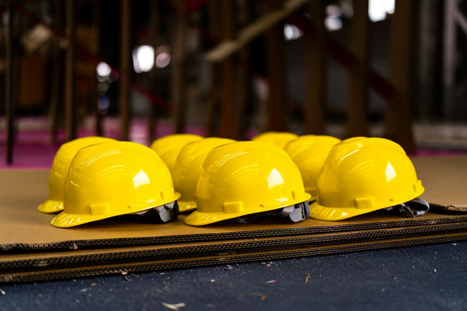 Yellow construction hard hats on cardboard at a worksite